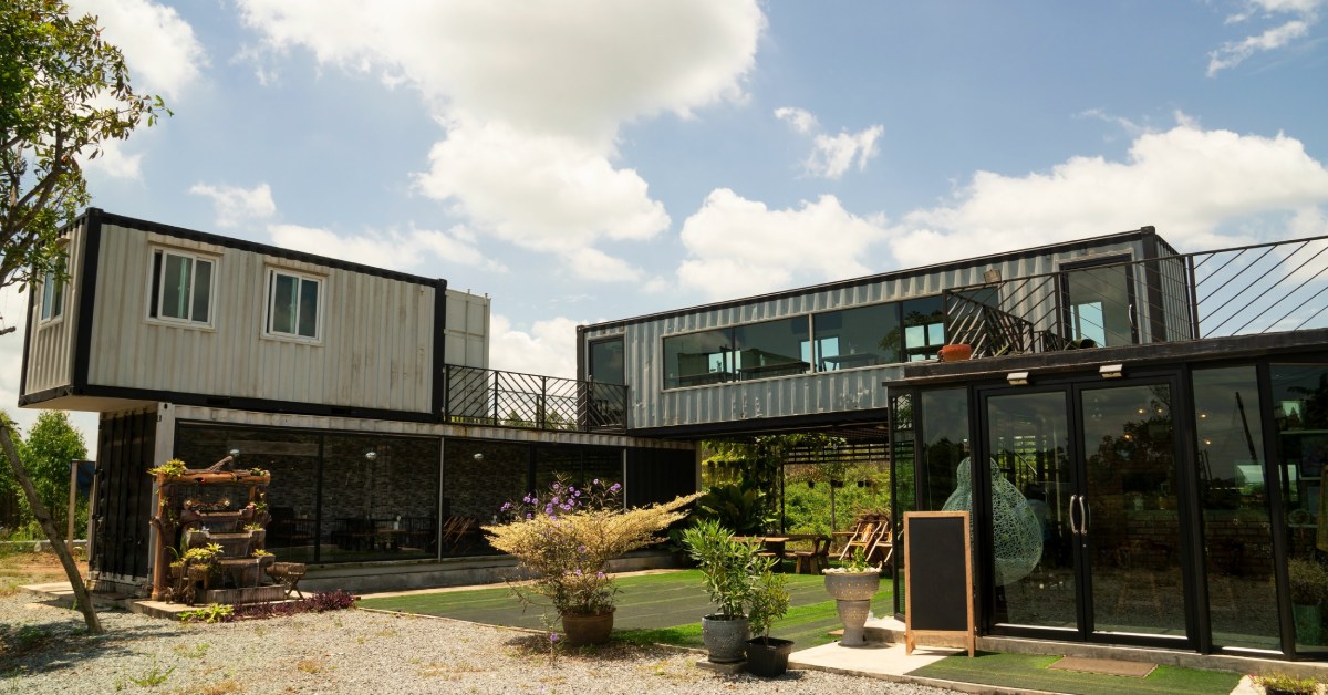 The sun shines on a welcoming community space made from shipping containers, complete with a courtyard and a glass atrium.